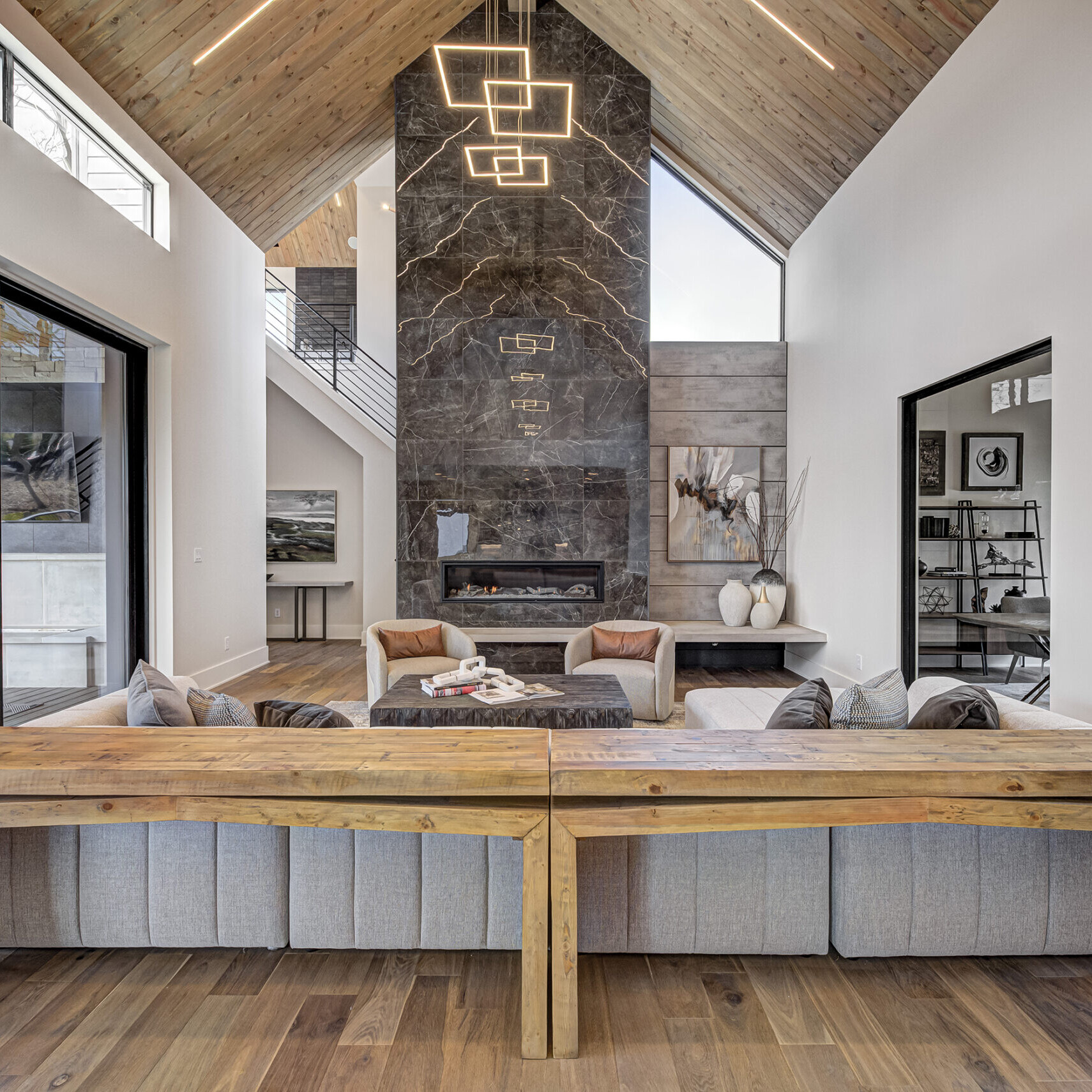 A modern living room with wood ceilings and a fireplace.