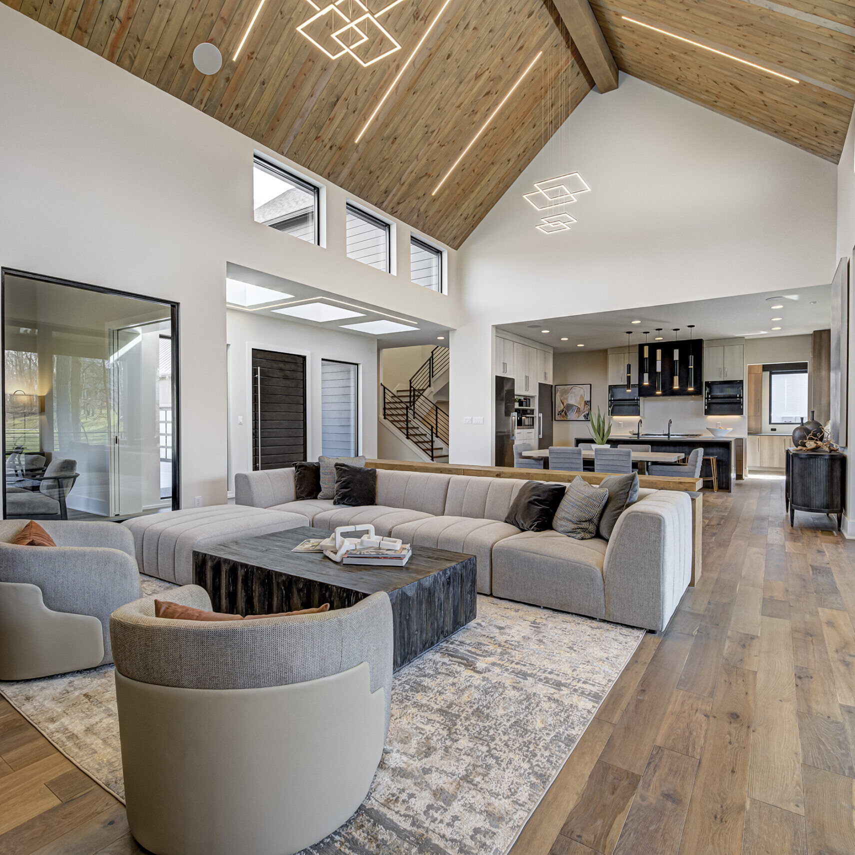 A modern living room with wood ceilings and hardwood floors.