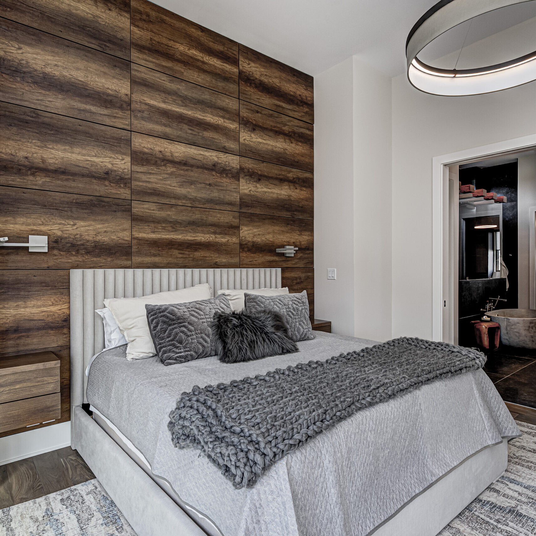 A bedroom with wood paneling and a bed.