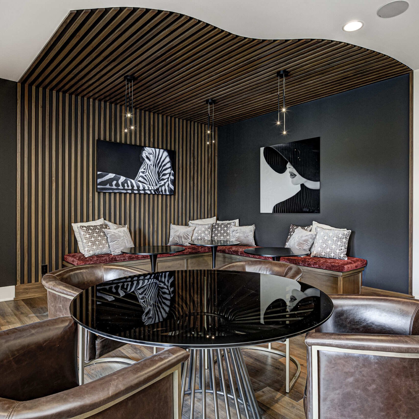 A dining room with a black table and chairs.