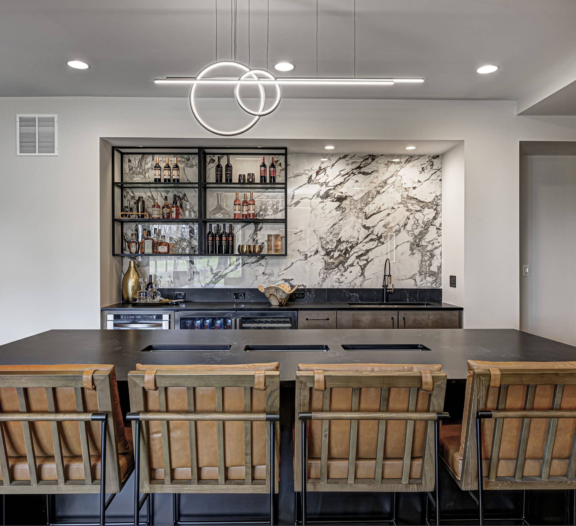 A kitchen with a marble counter top and stools.