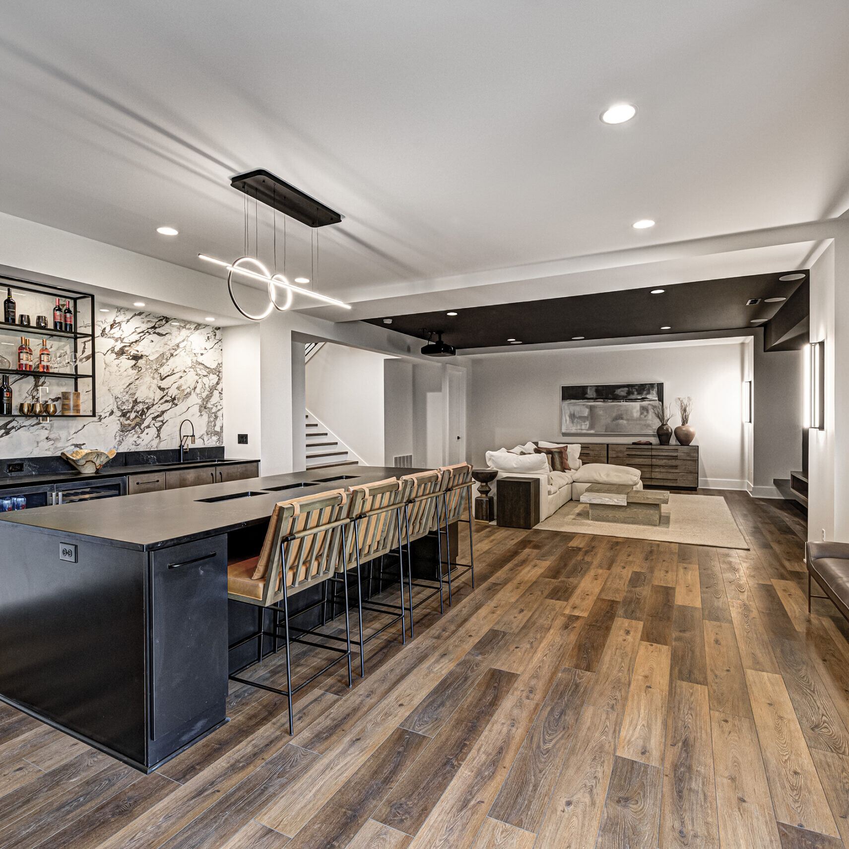 A modern kitchen with wood floors and a bar area.
