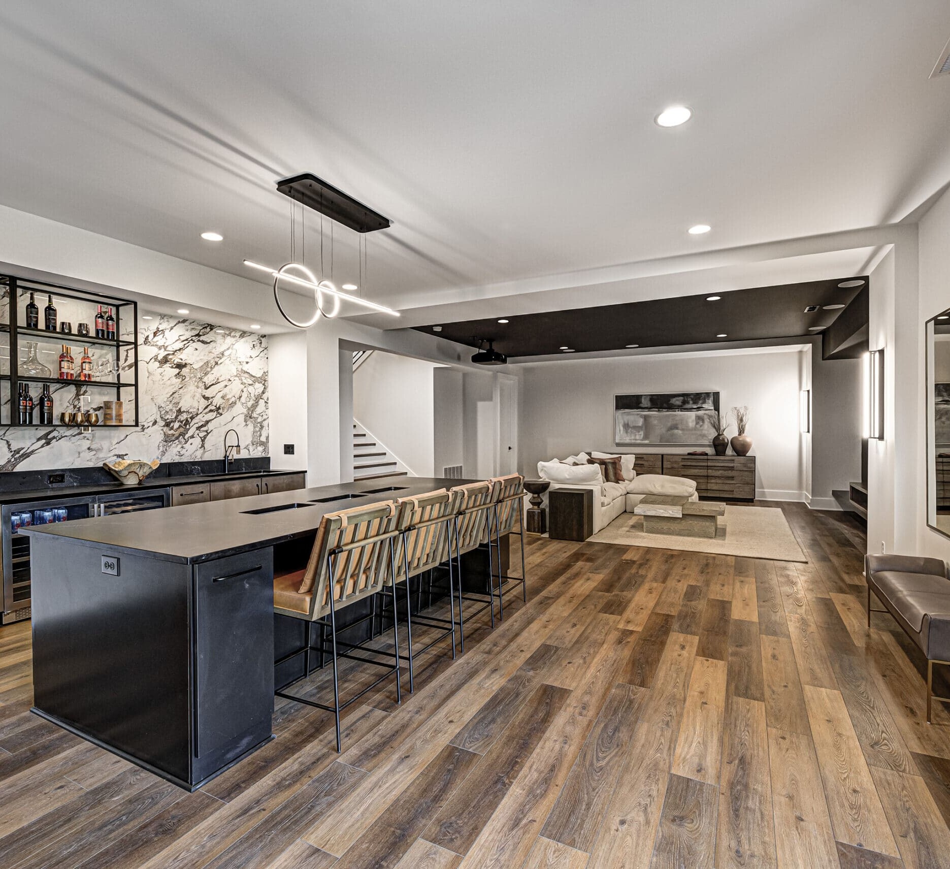 A modern kitchen with wood floors and a bar area.