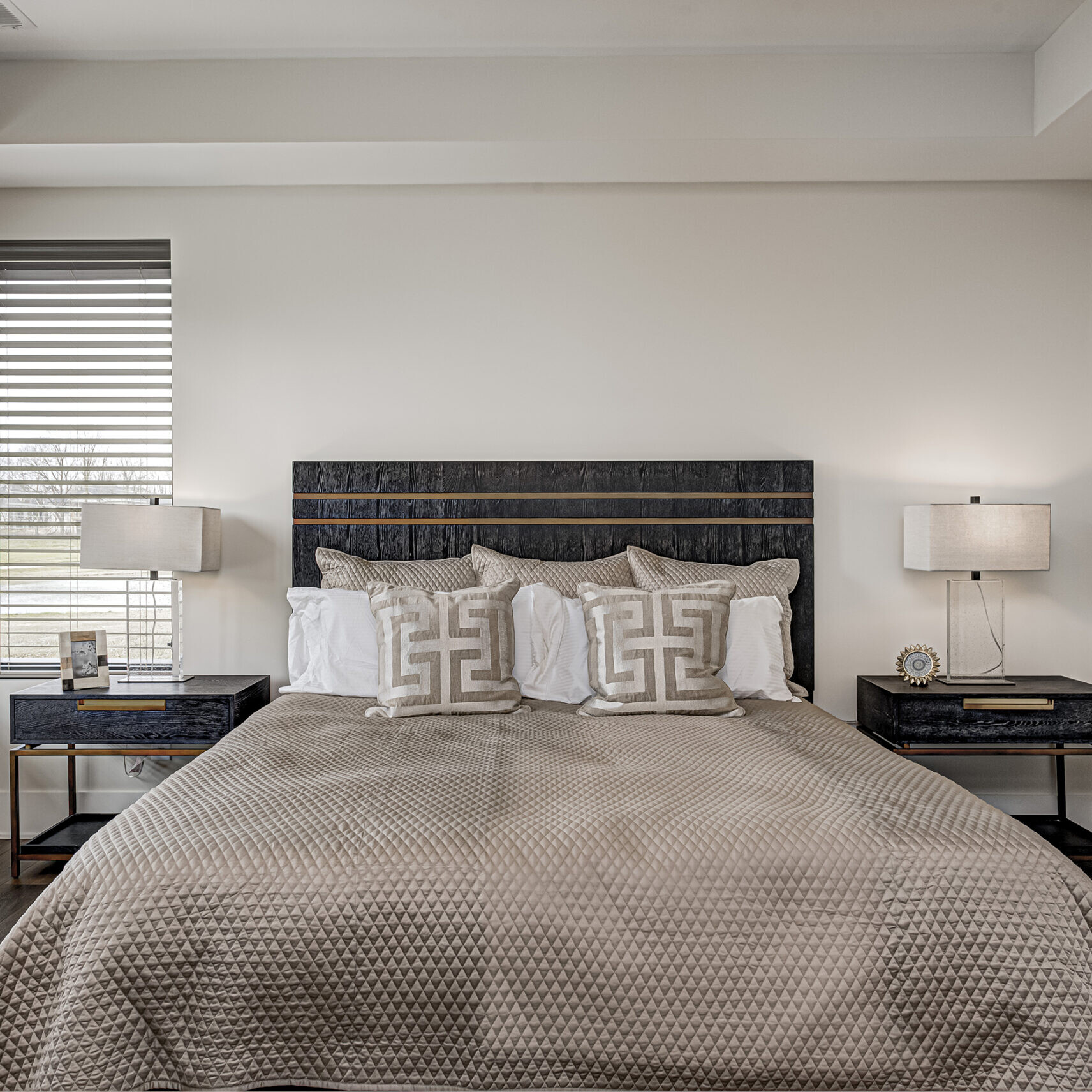 A bedroom with hardwood floors and a bed.