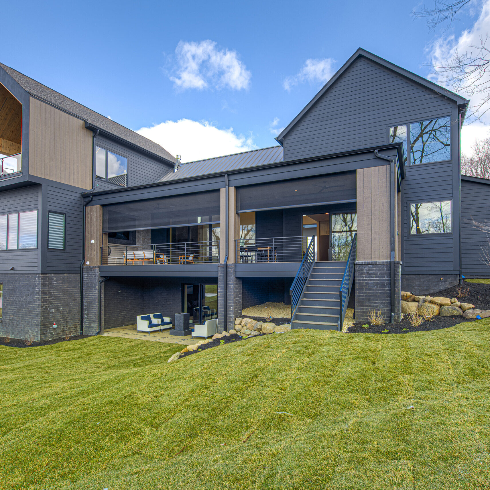 A home with a black exterior and a grassy yard.