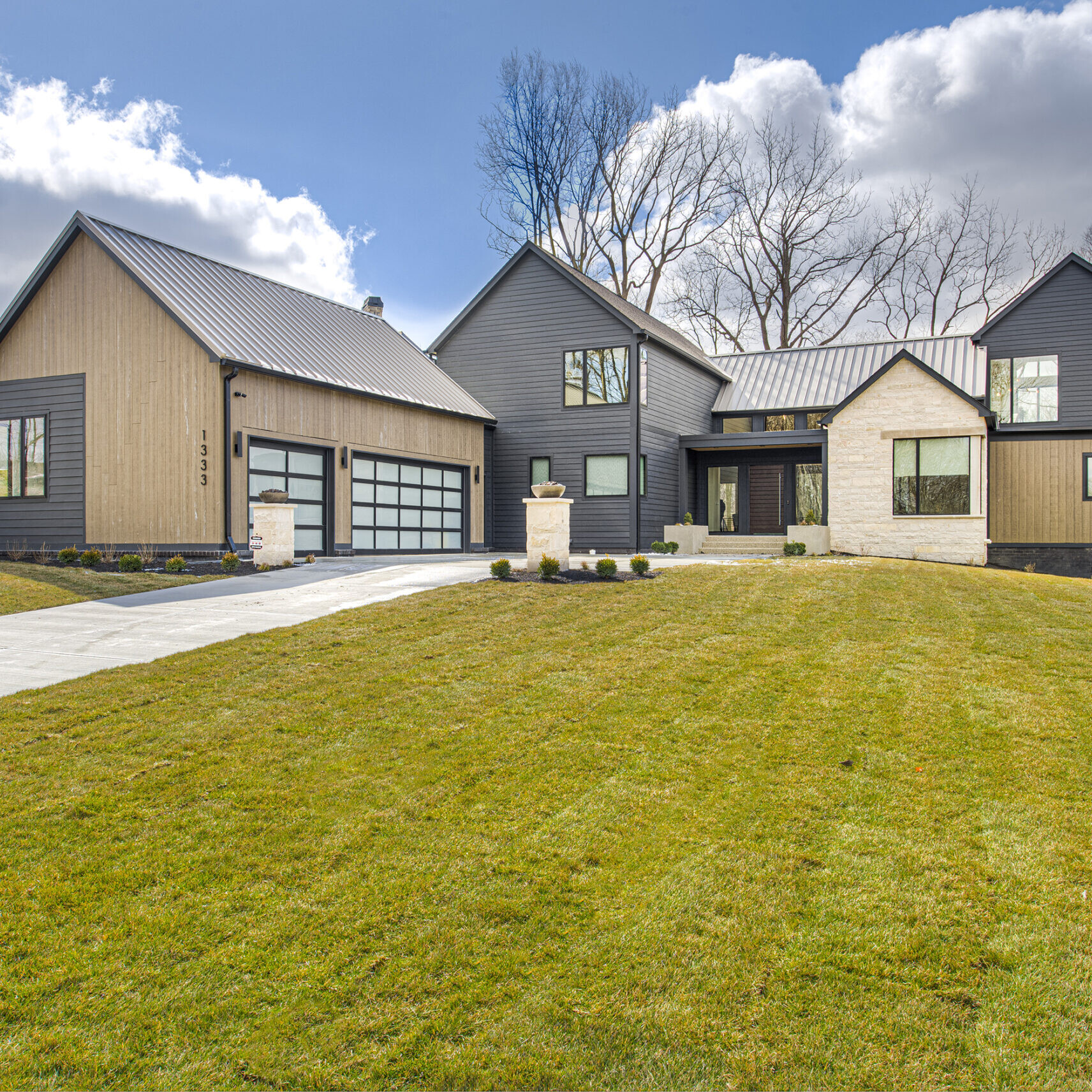 A black and gray home with a grassy yard.
