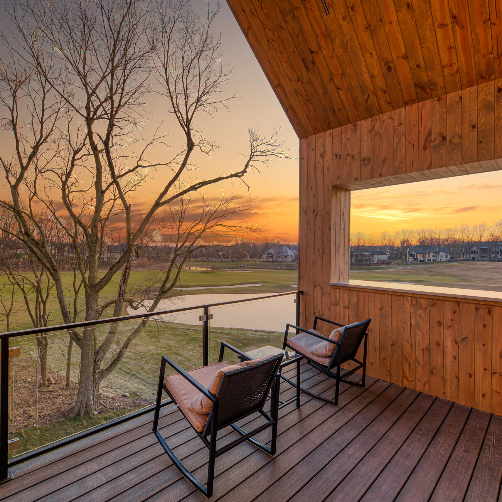 A wooden deck with a view of a field.