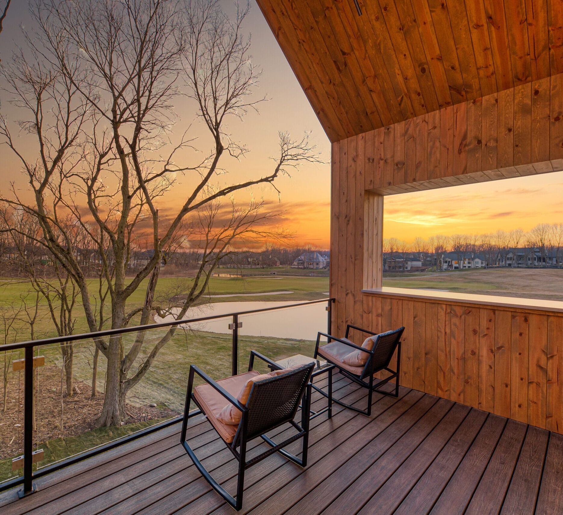 A wooden deck with a view of a field.