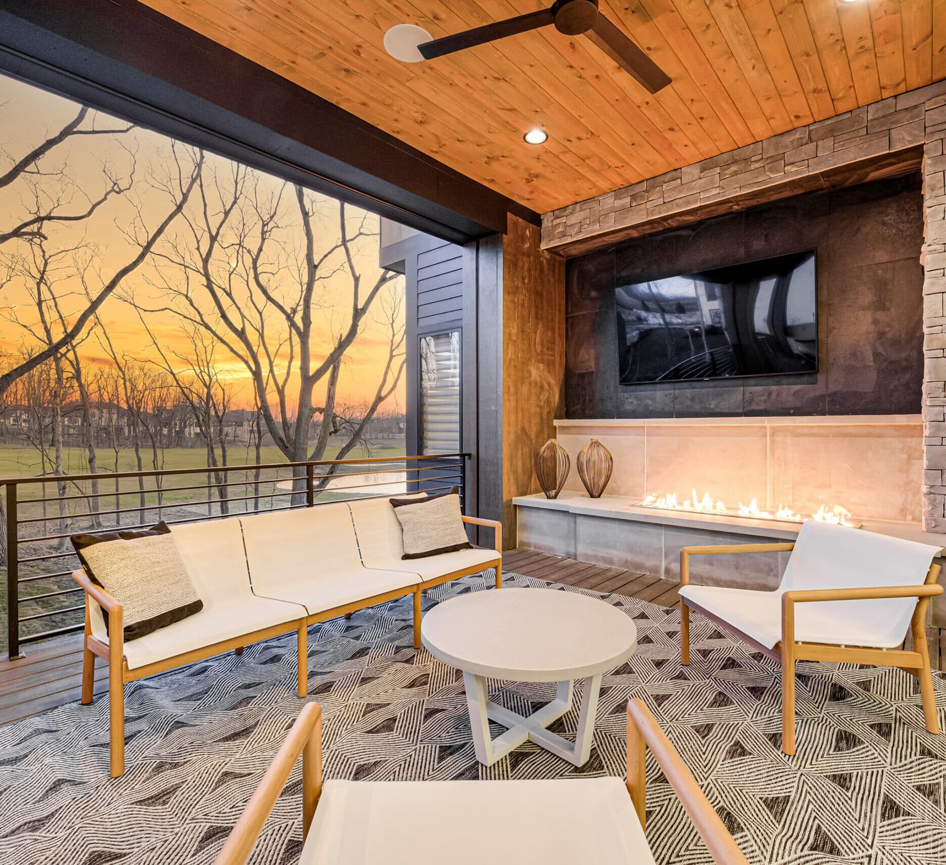 An outdoor living area with a fireplace and tv.