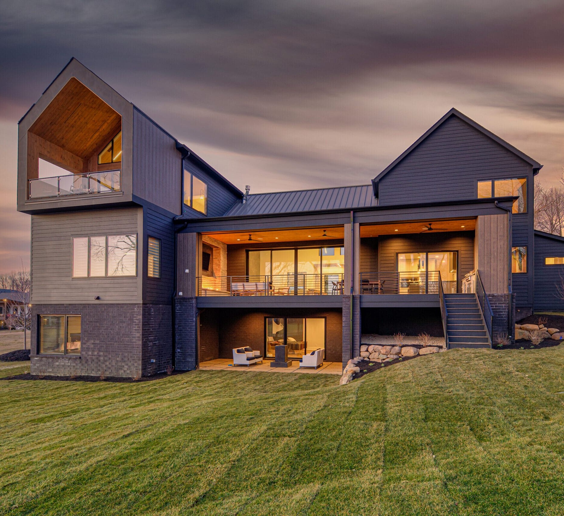 A modern home on a hillside at dusk.