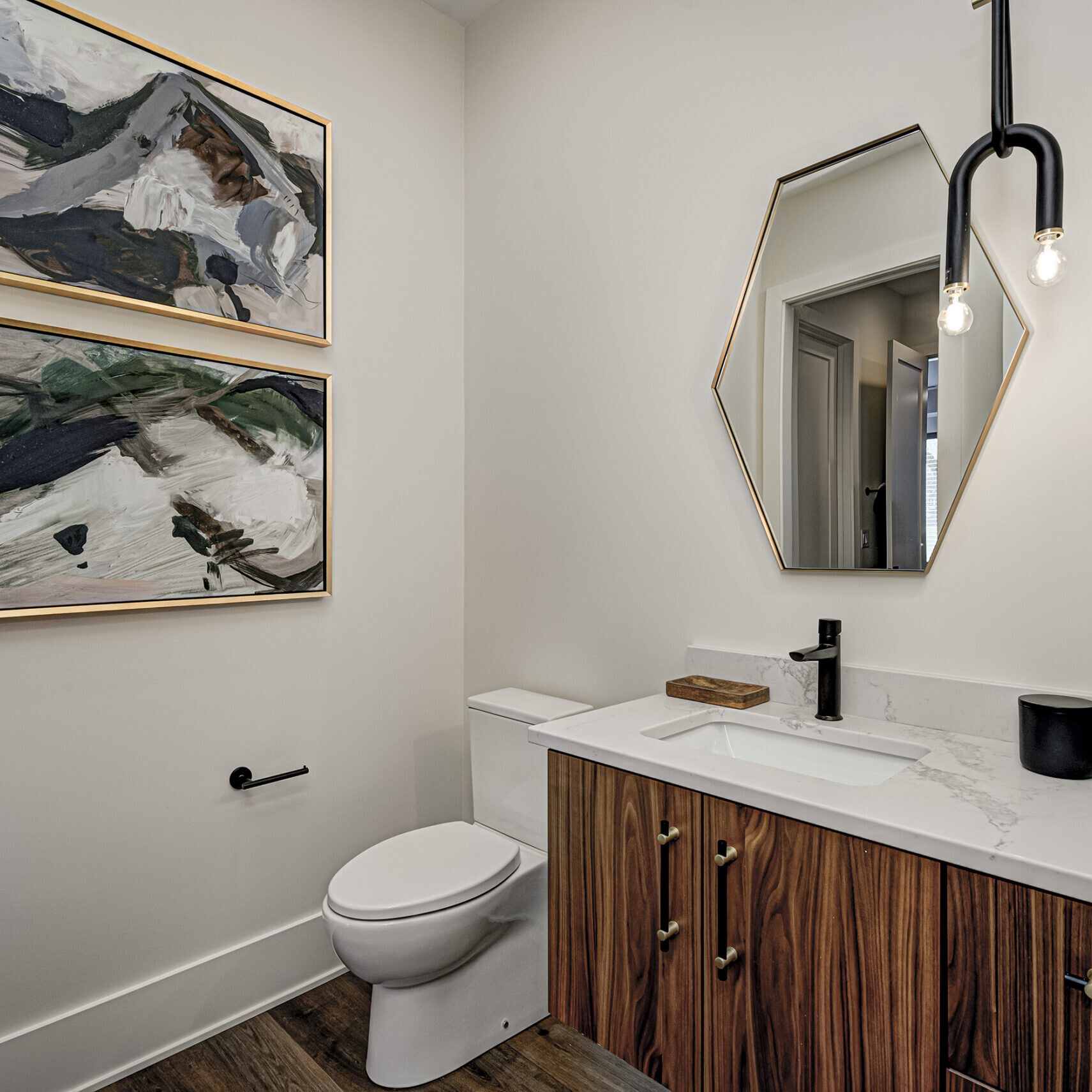 A bathroom with a toilet, sink and mirror.