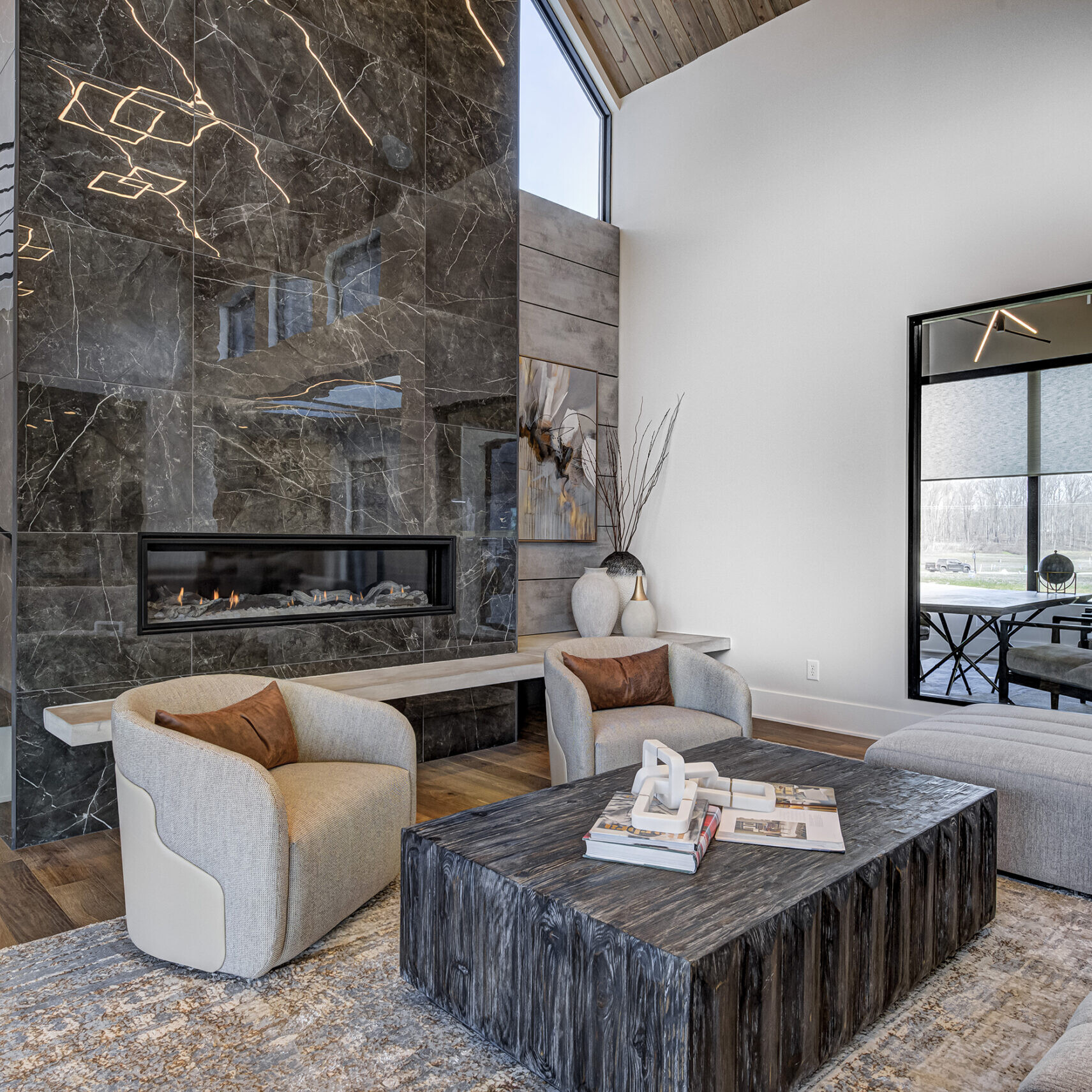 A modern living room with a fireplace and stairs.