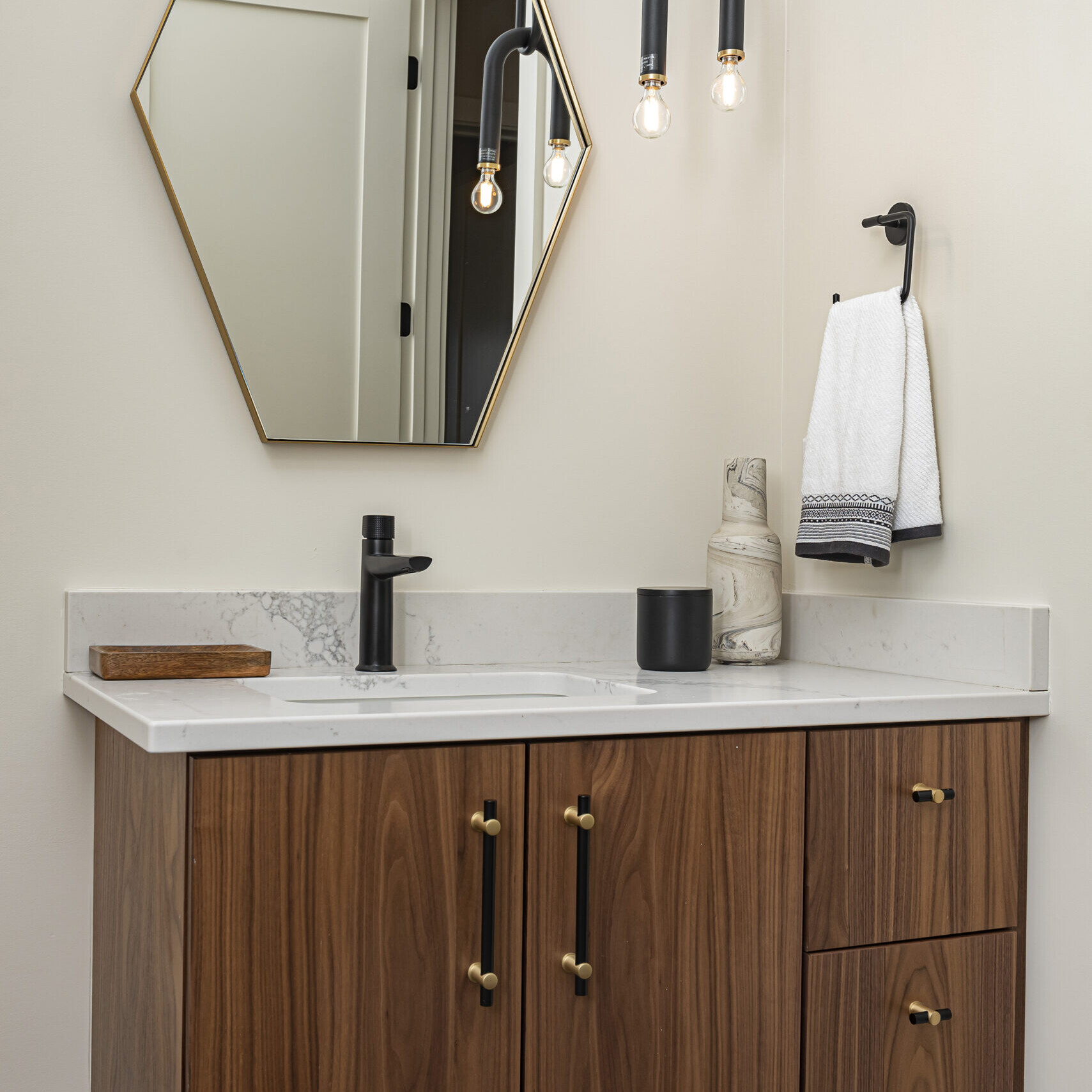 A bathroom with a wooden vanity and mirror.