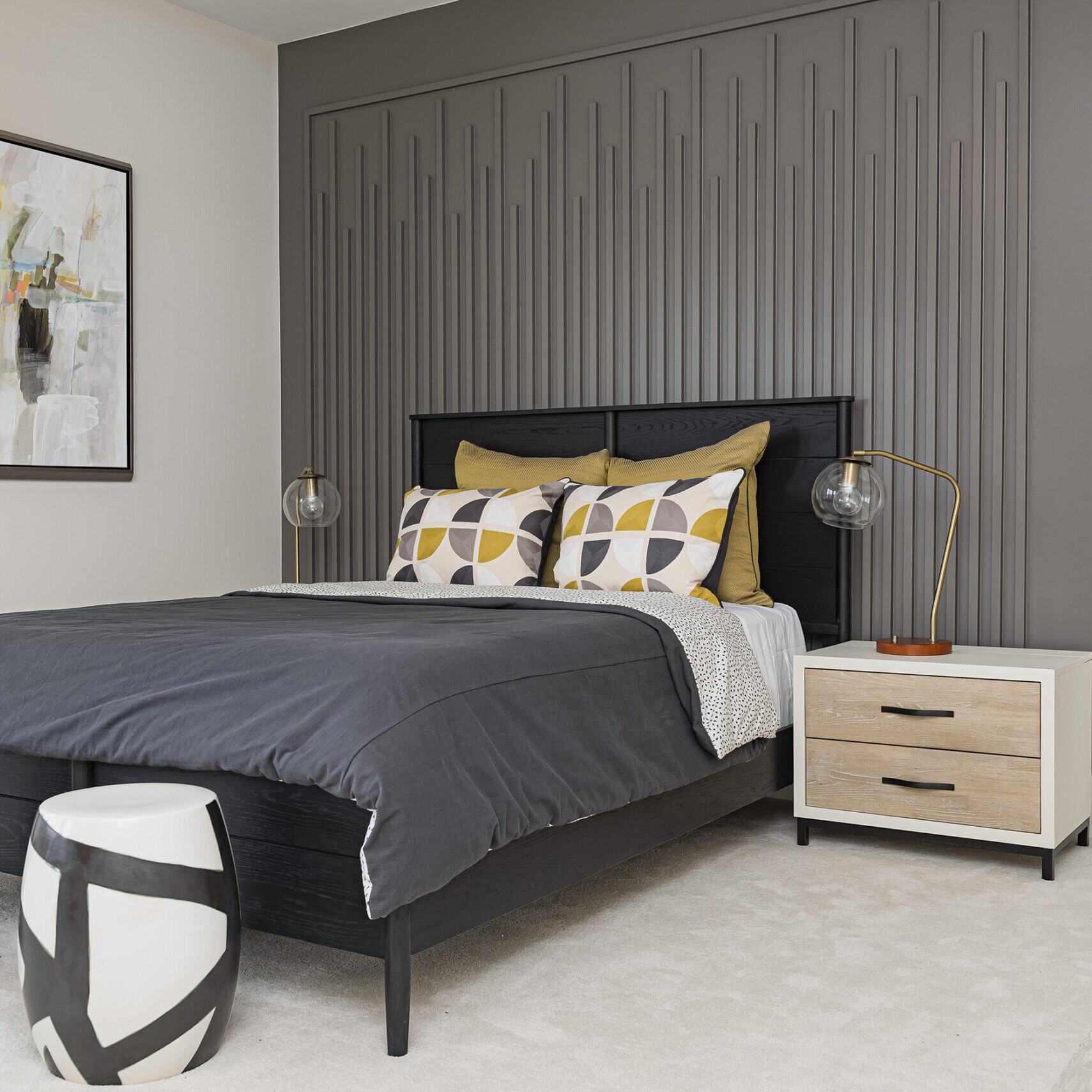 A bedroom with gray walls and yellow accents.