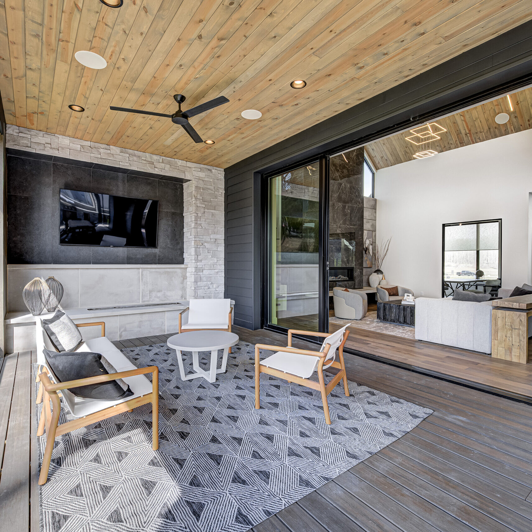 A modern home with a wooden deck and a tv.