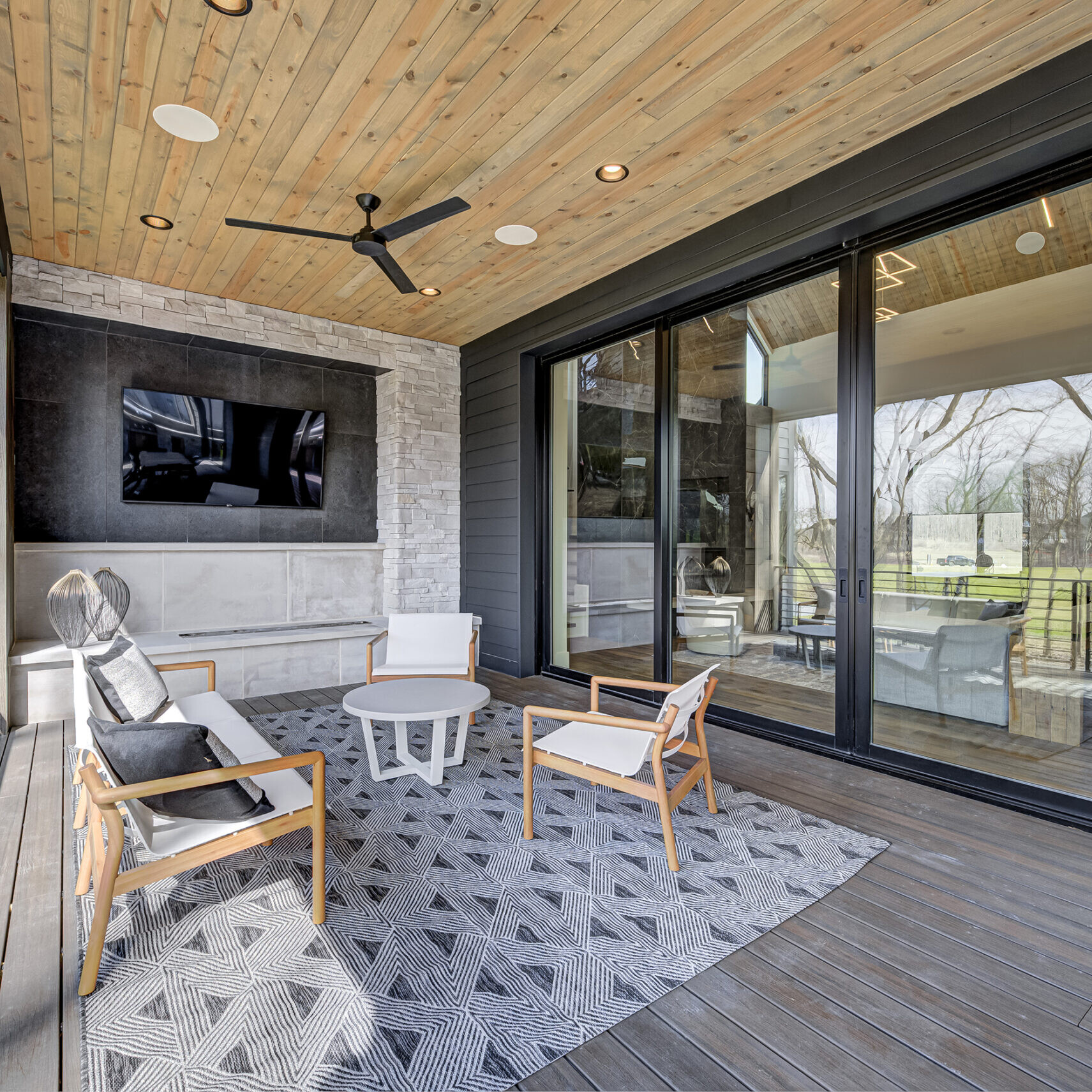 A modern home with a large deck and a tv.