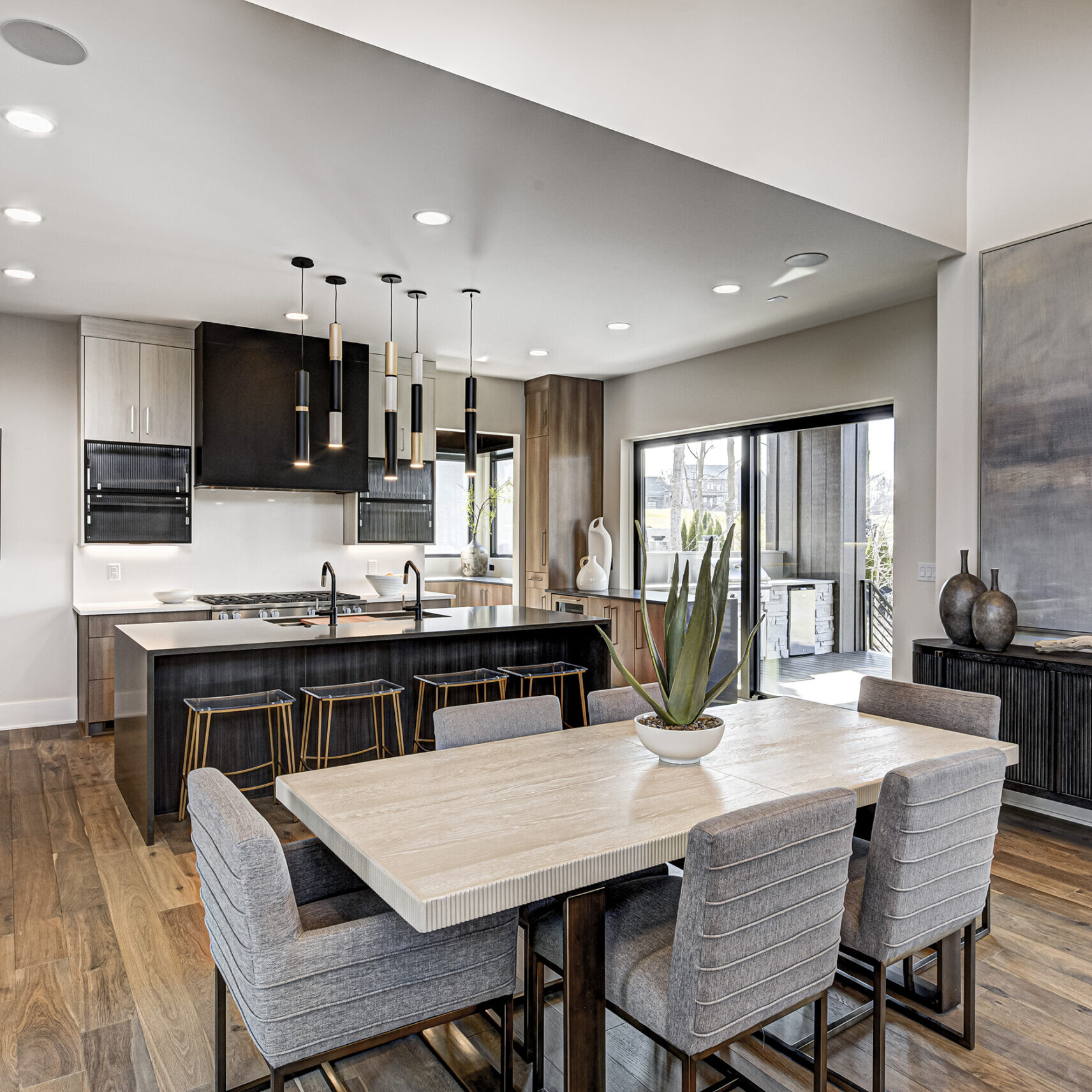 A modern kitchen with hardwood floors and a dining table.