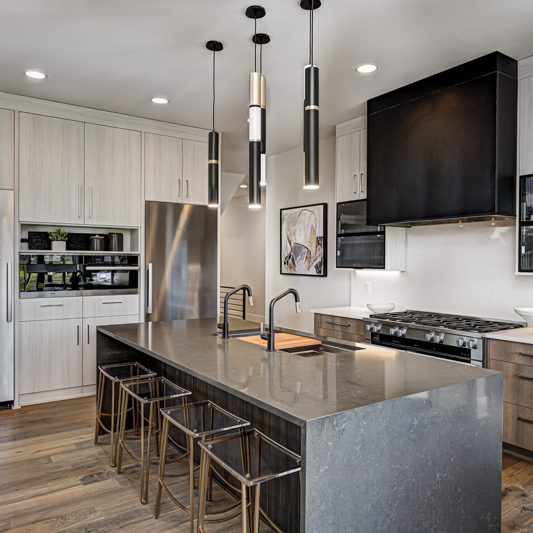 A modern kitchen with stainless steel appliances and wood floors.