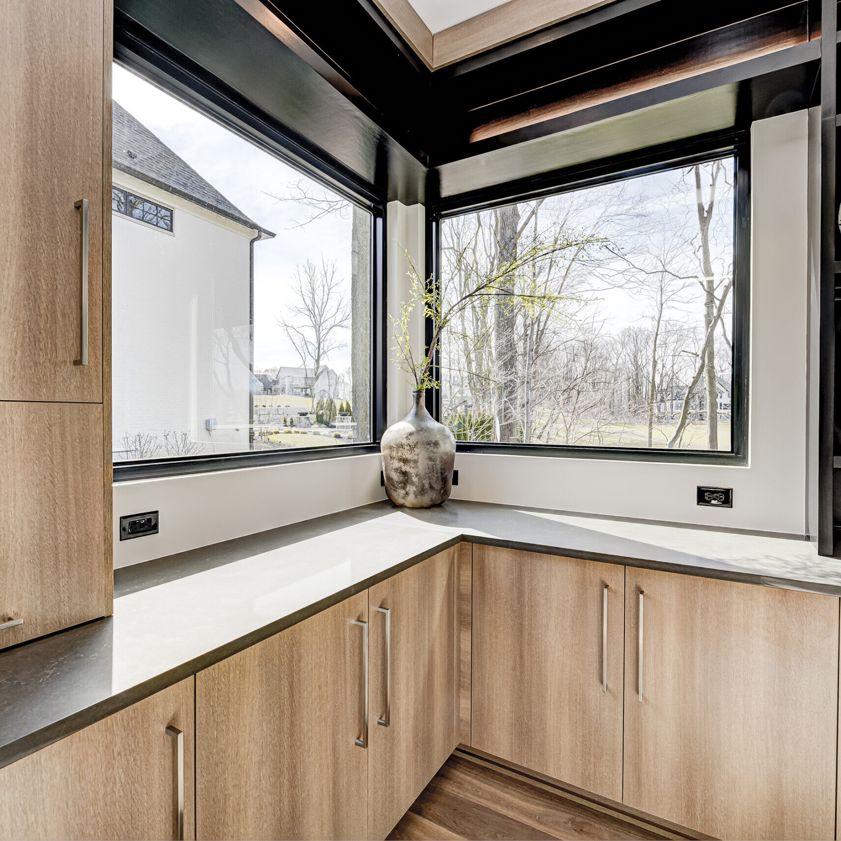 A kitchen with wood cabinets and a window.