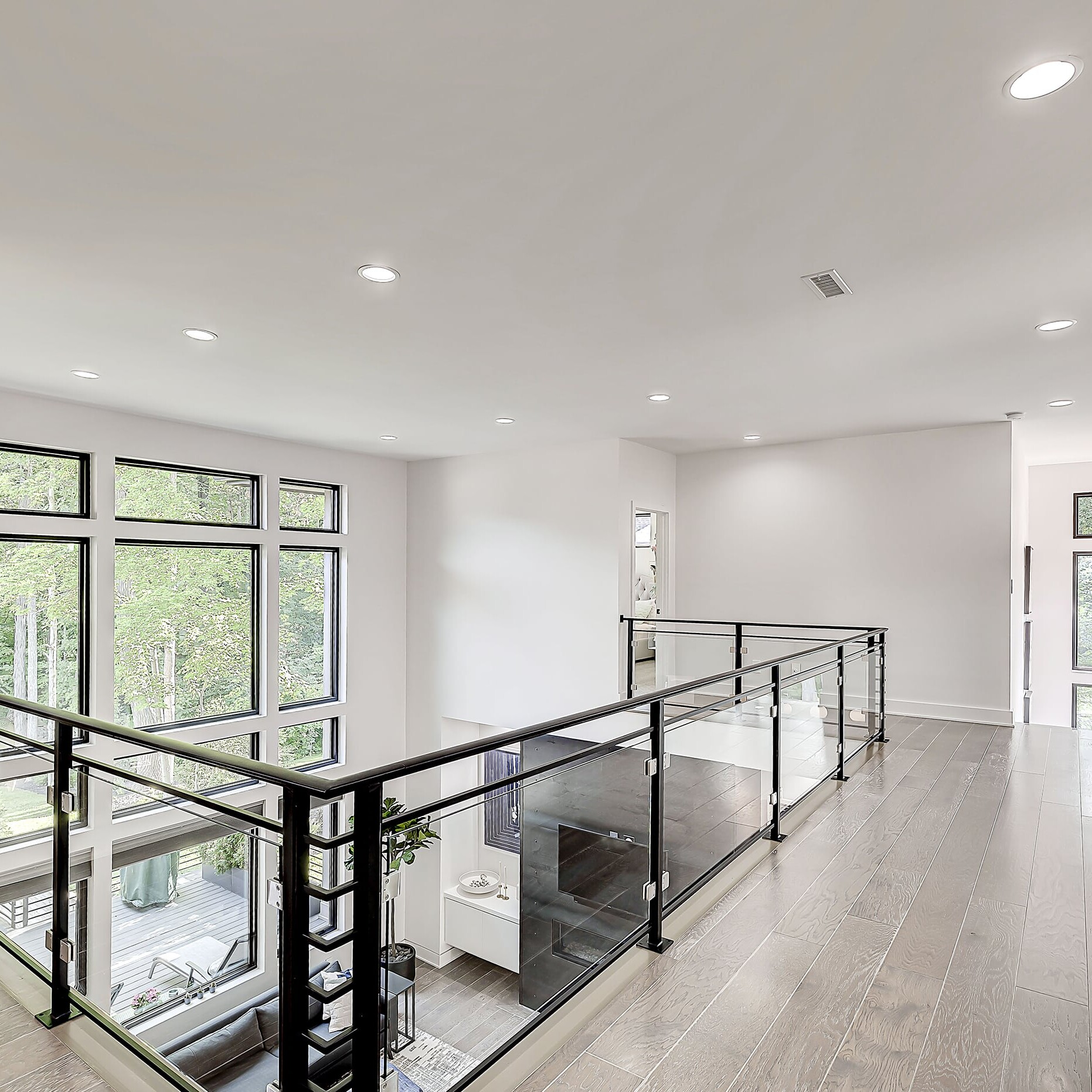 A home with hardwood floors and glass railings.