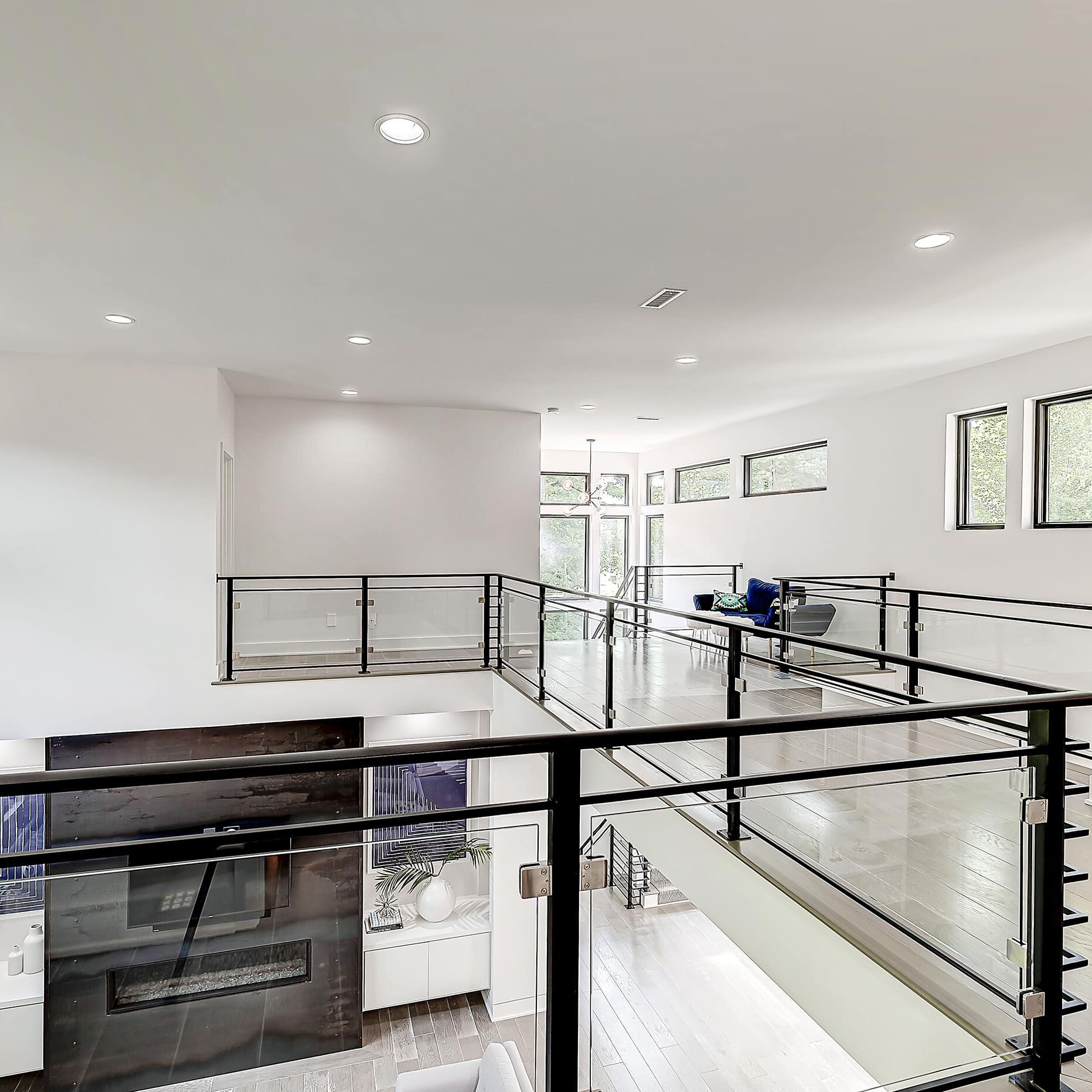 A modern home with a glass railing and stairs.