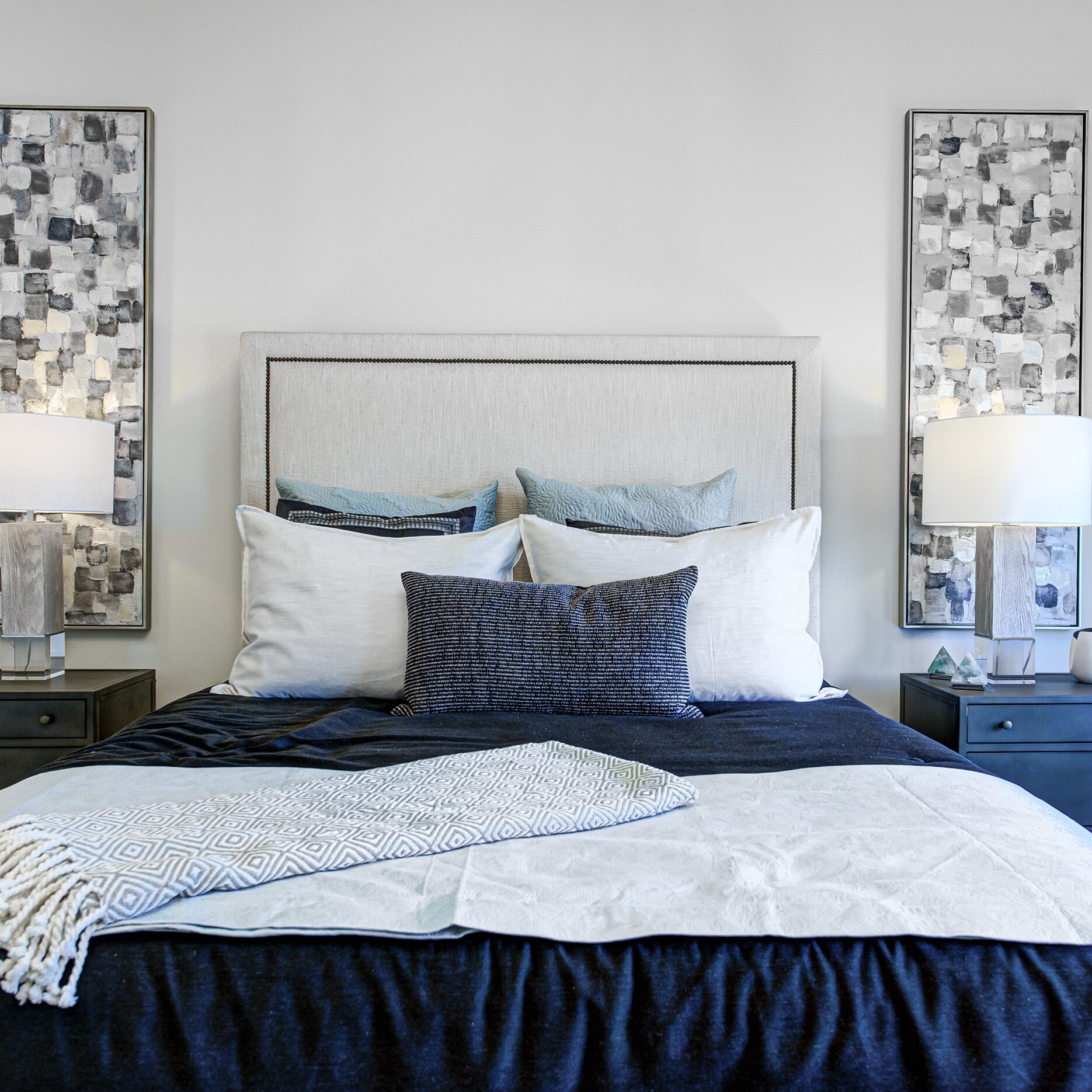 A bed with a blue and white comforter.