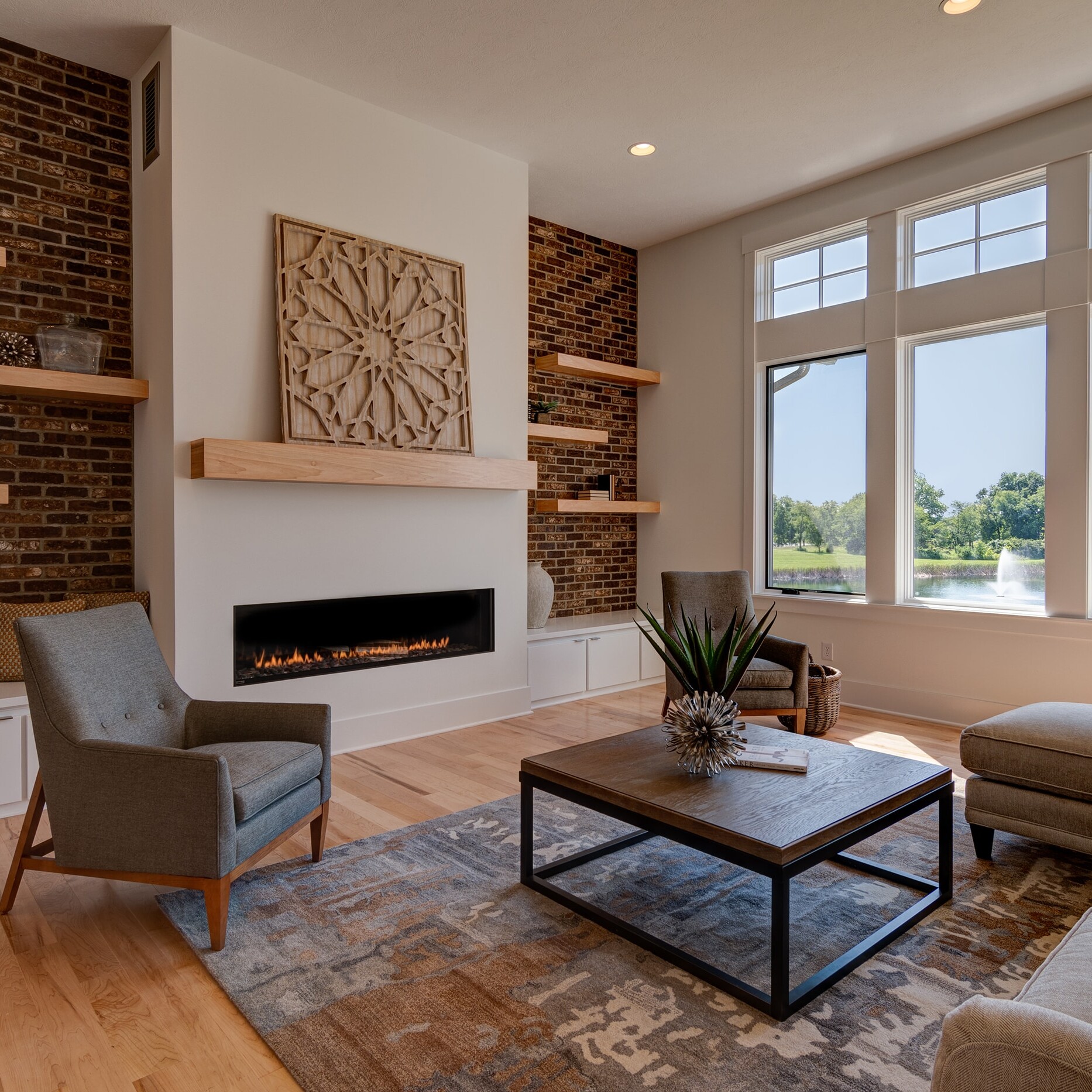 A living room with a brick fireplace and hardwood floors.