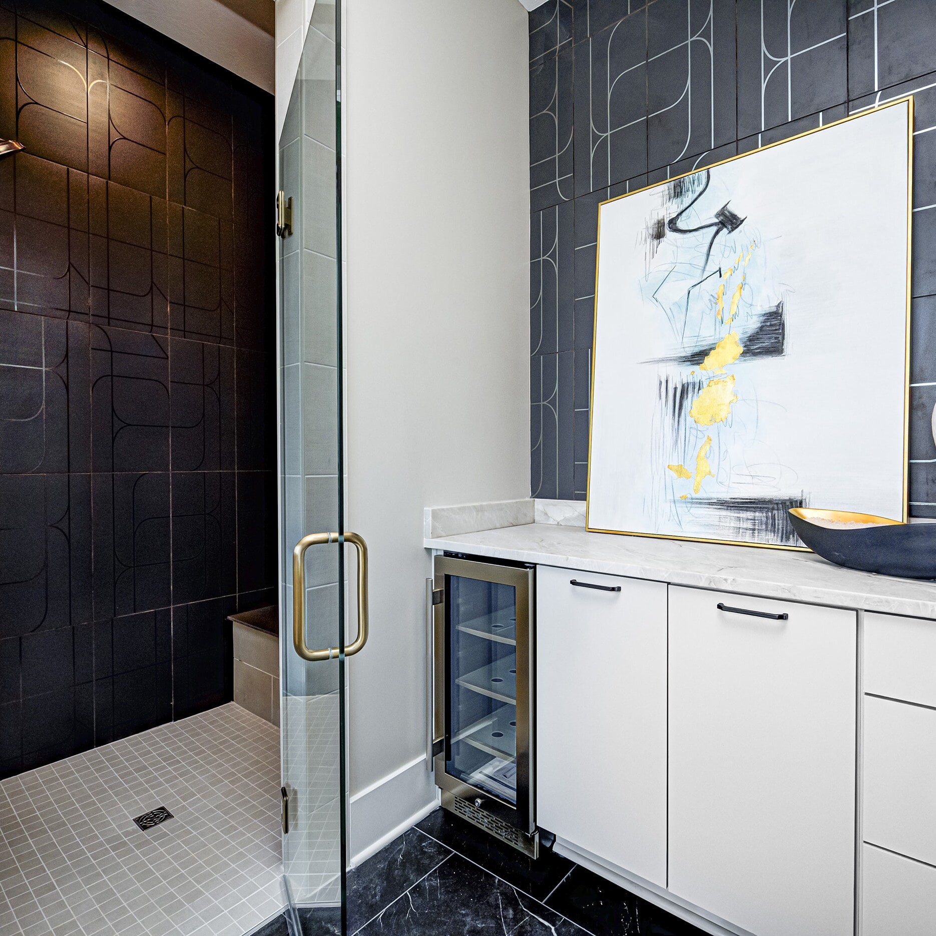 A bathroom with a black and white tiled shower.