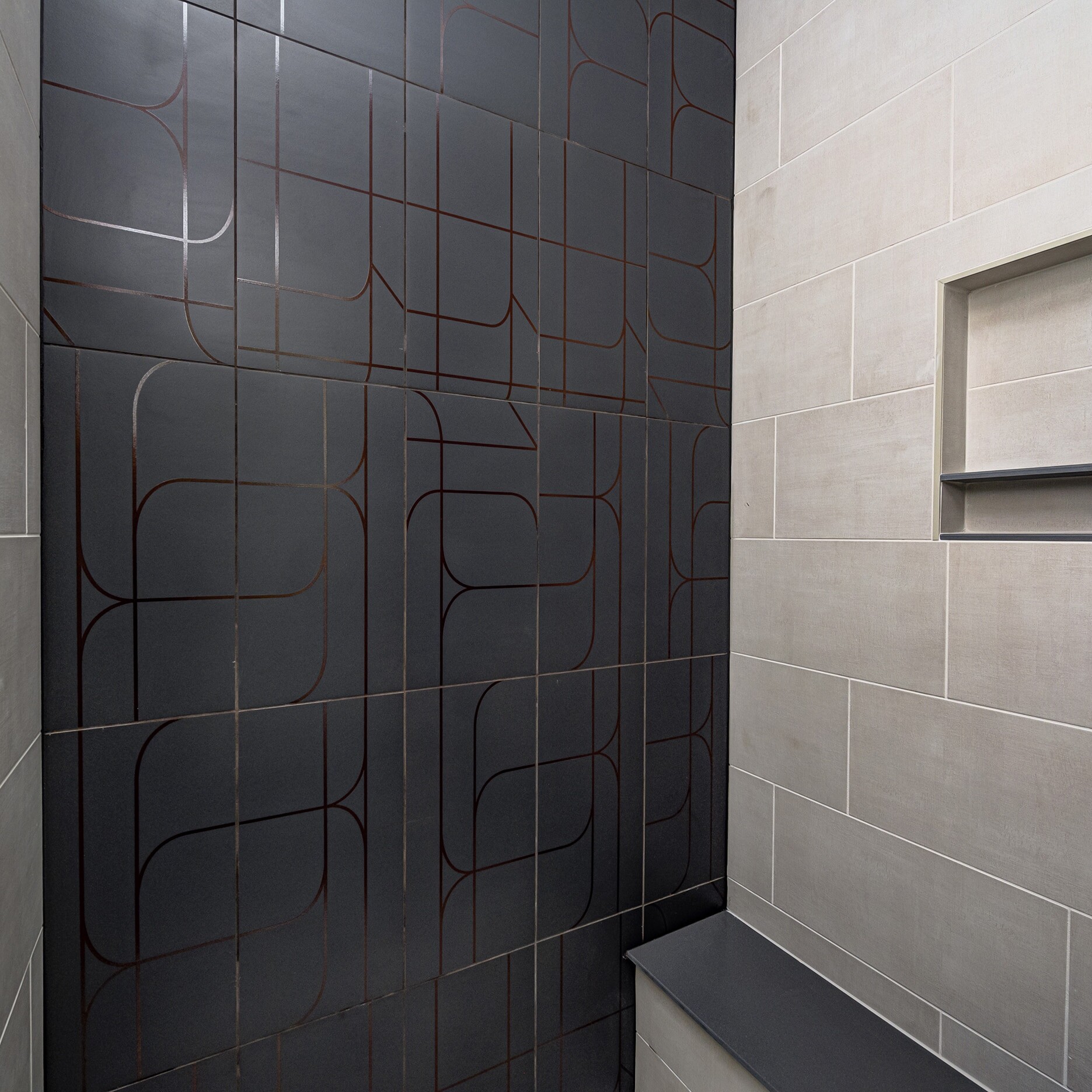 A tiled shower with a bench.