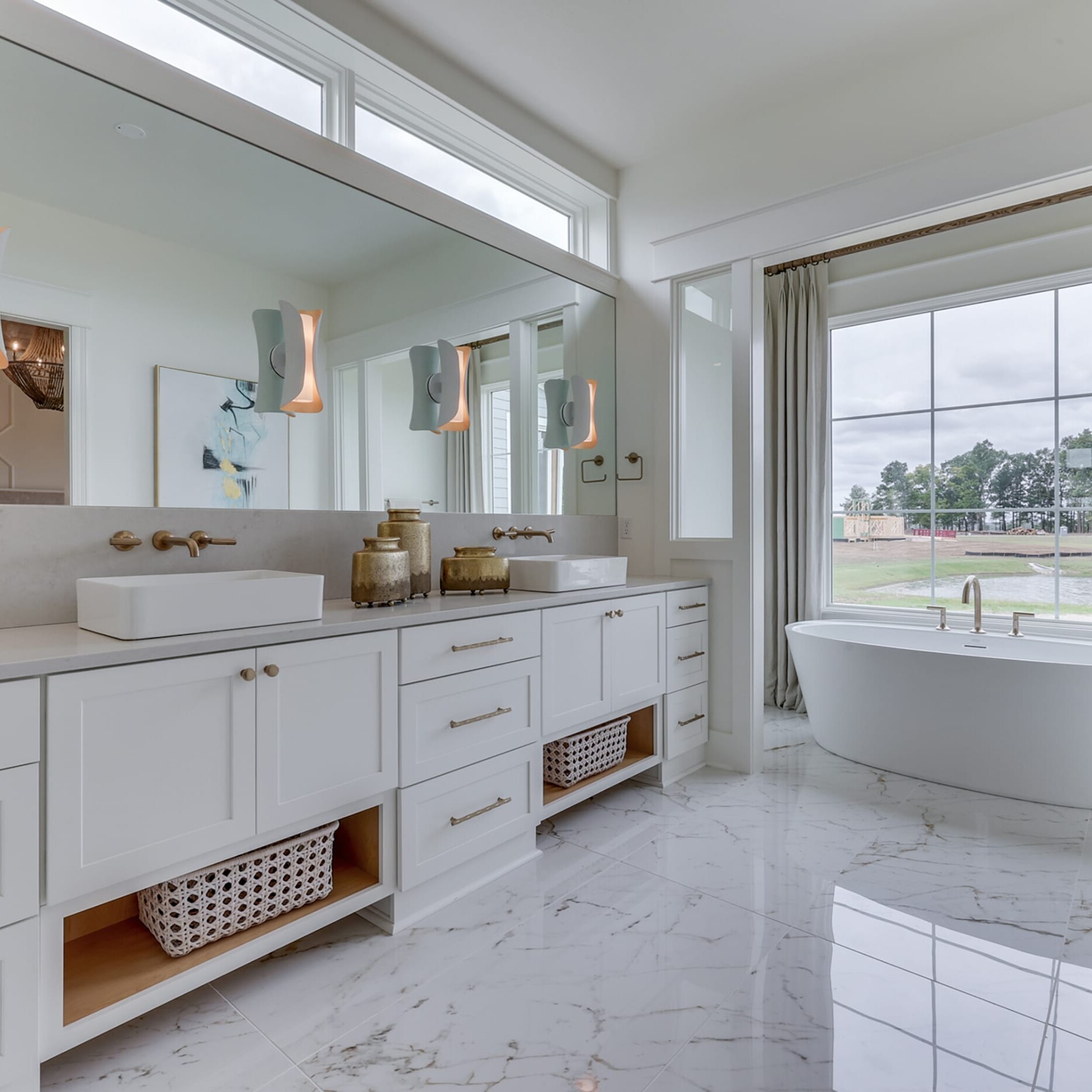 A large bathroom with white cabinets and a tub.
