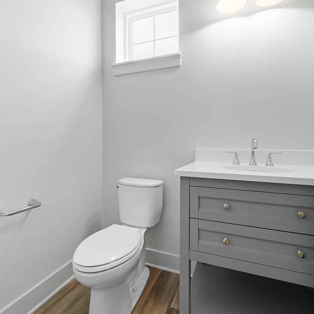 A small bathroom with a toilet and sink, designed by a luxury custom home builder in Carmel Indiana.