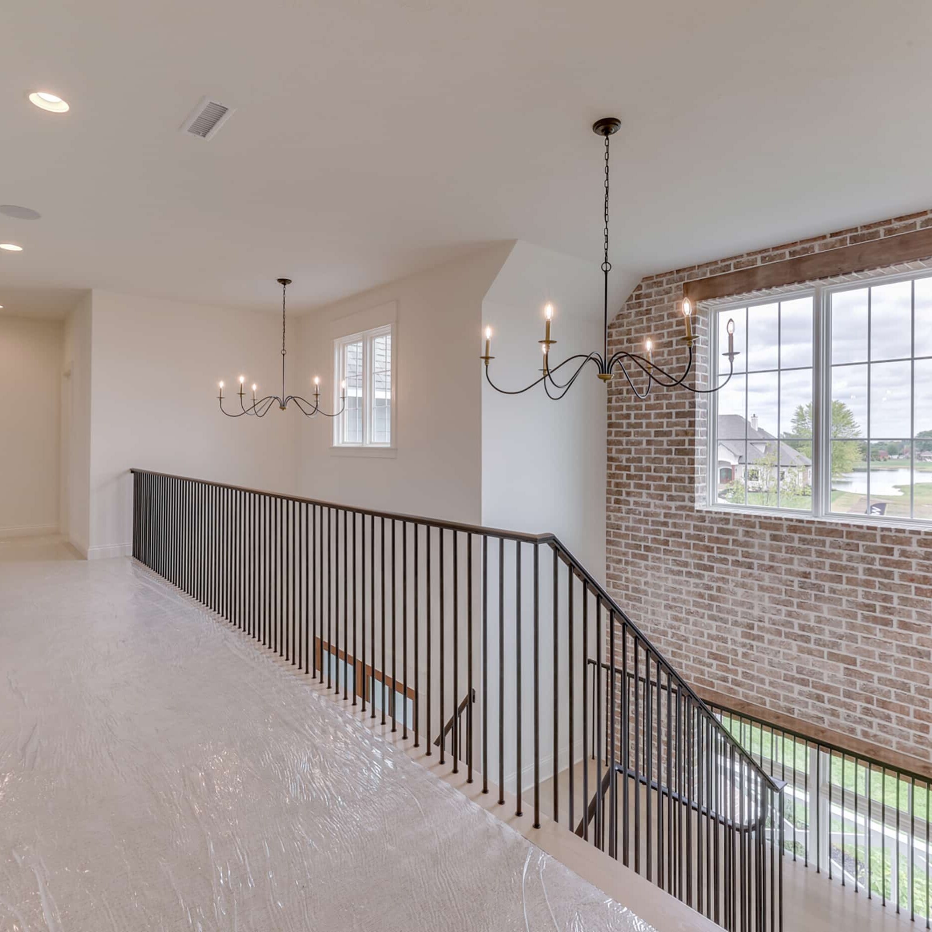 A stairway in a home with brick walls and a chandelier.