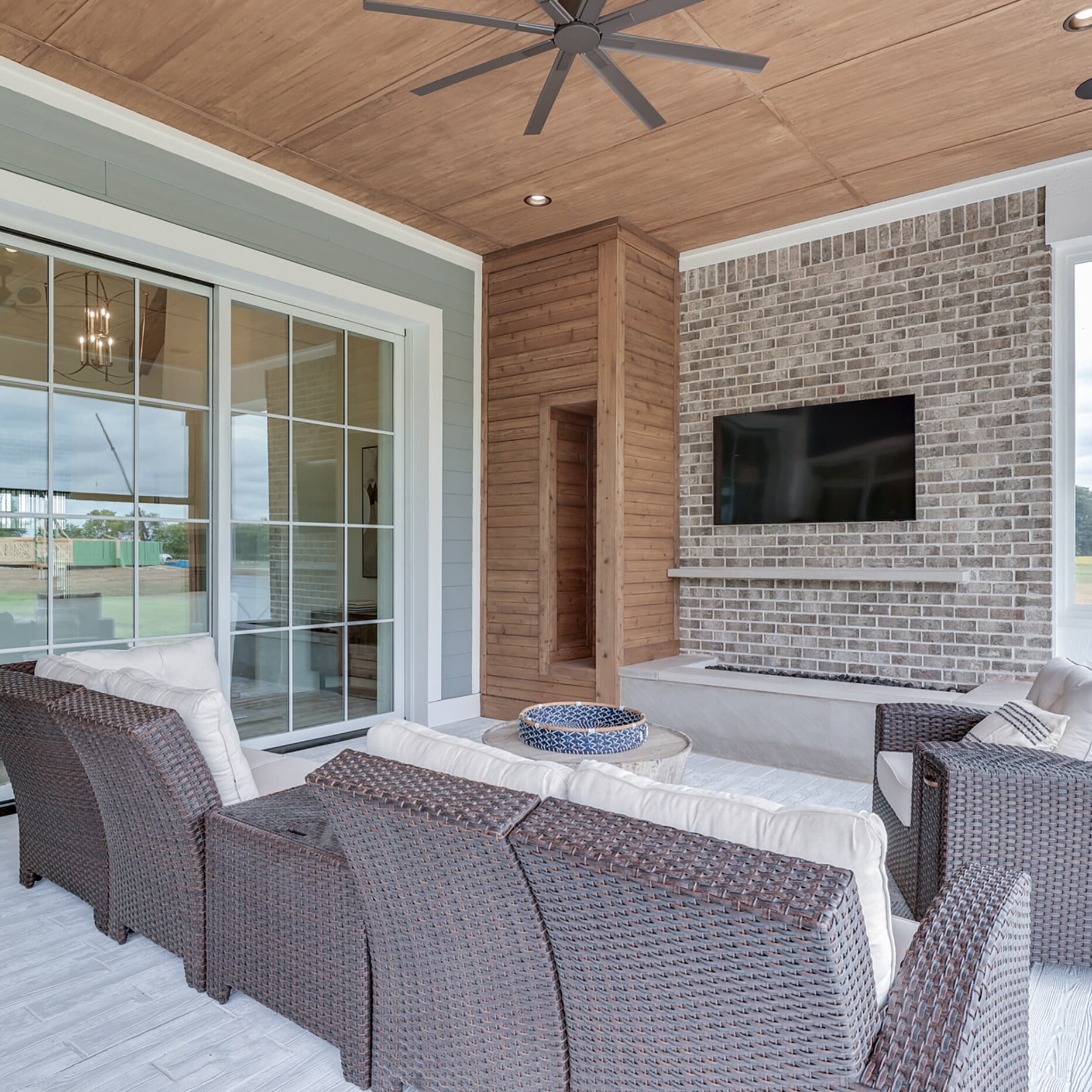 An outdoor living area with wicker furniture and a tv.