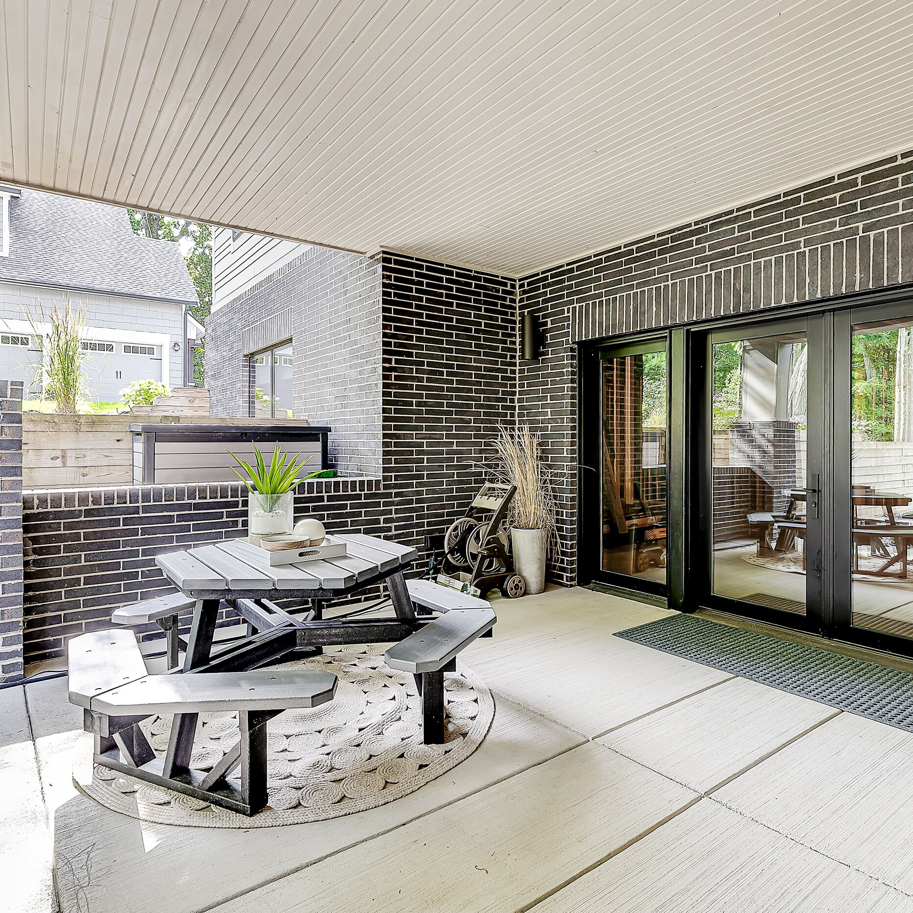 A brick patio with a table and chairs.
