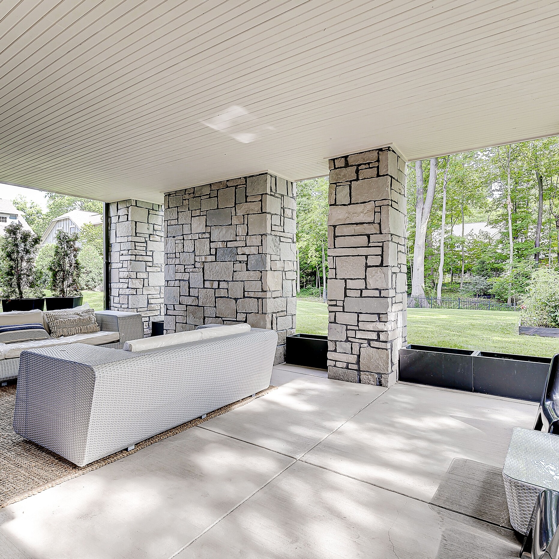 An outdoor living area with couches and a fireplace.