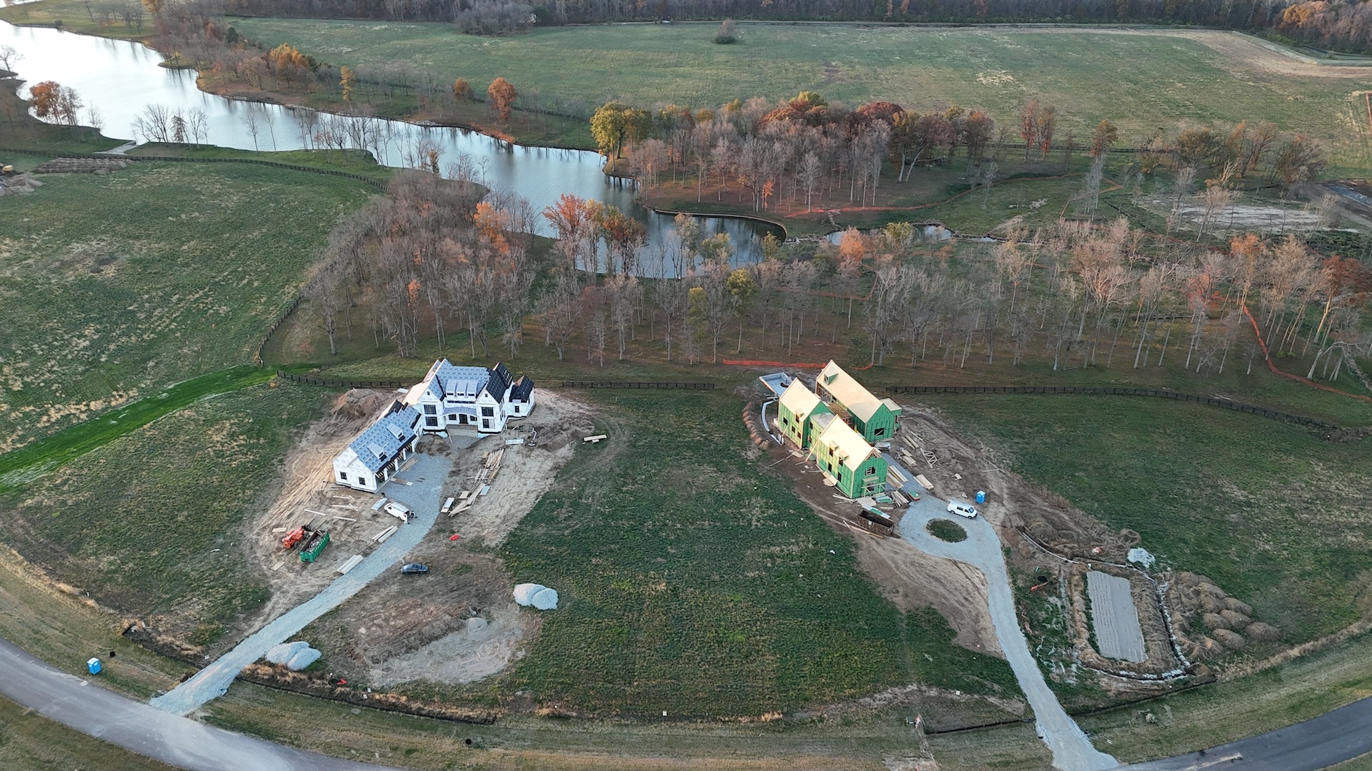 An aerial view of a house with a pond, showcasing the expertise of a luxury custom home builder in Carmel, Indiana.