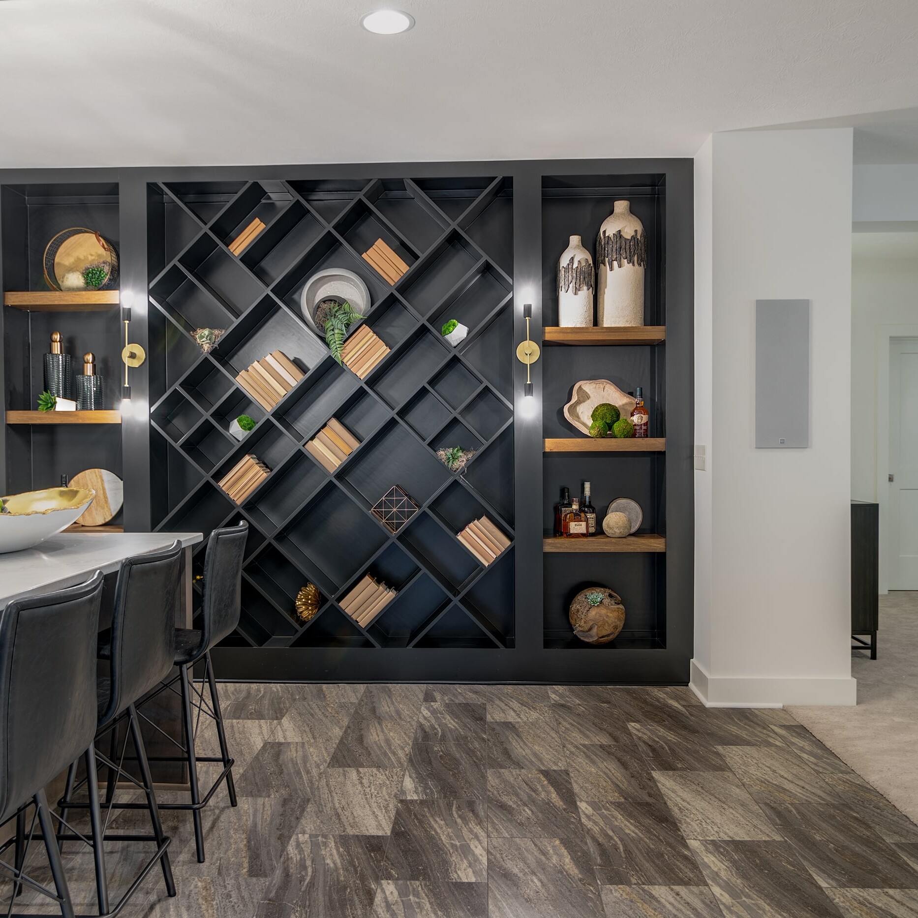 A kitchen with a black wine rack and bar stools.