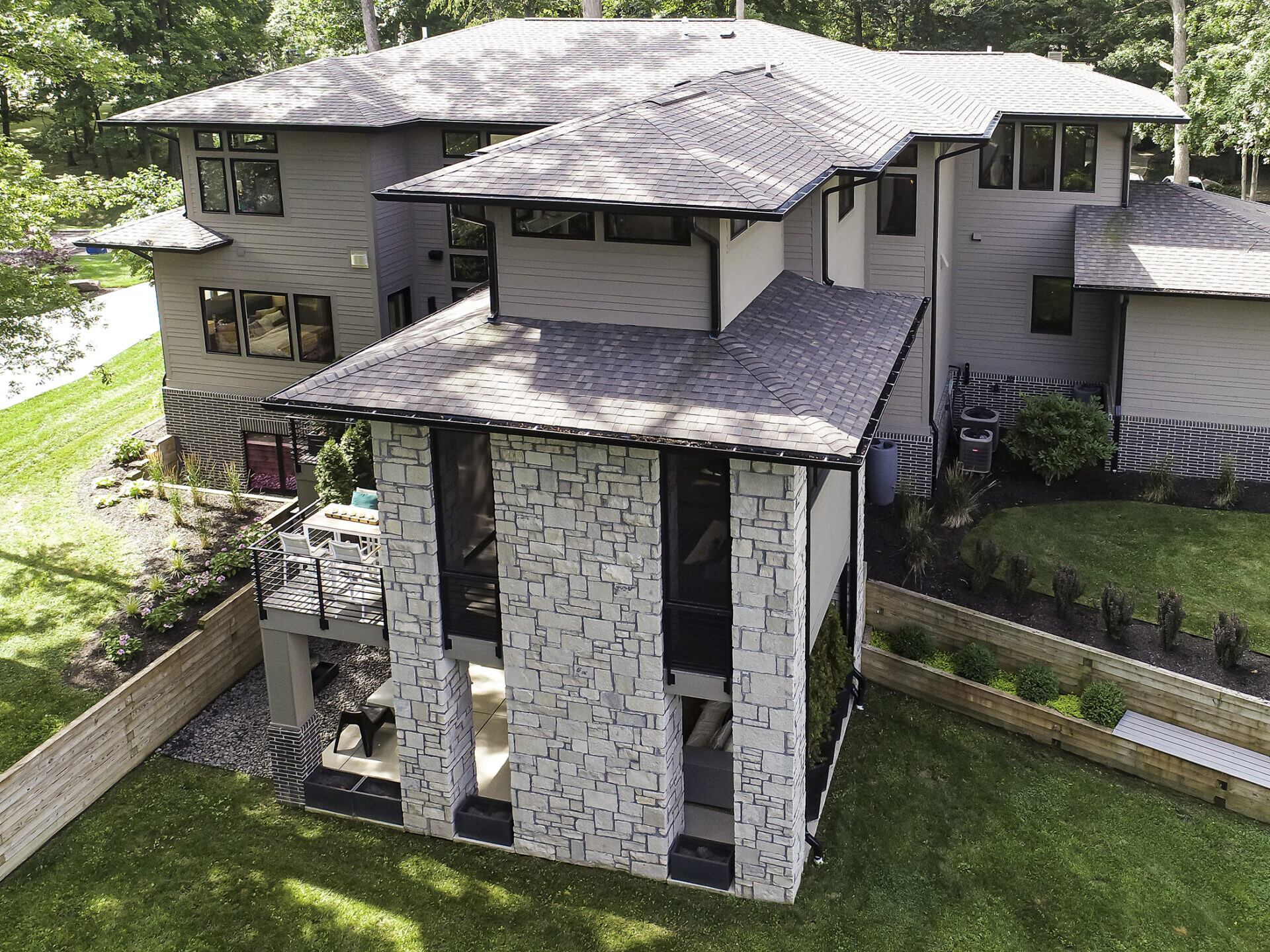An aerial view of a custom home in the woods.