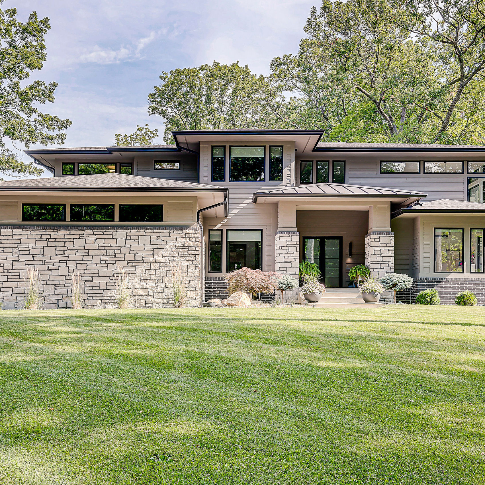 A modern home surrounded by a spacious grassy yard, built by Indianapolis Custom Homes.