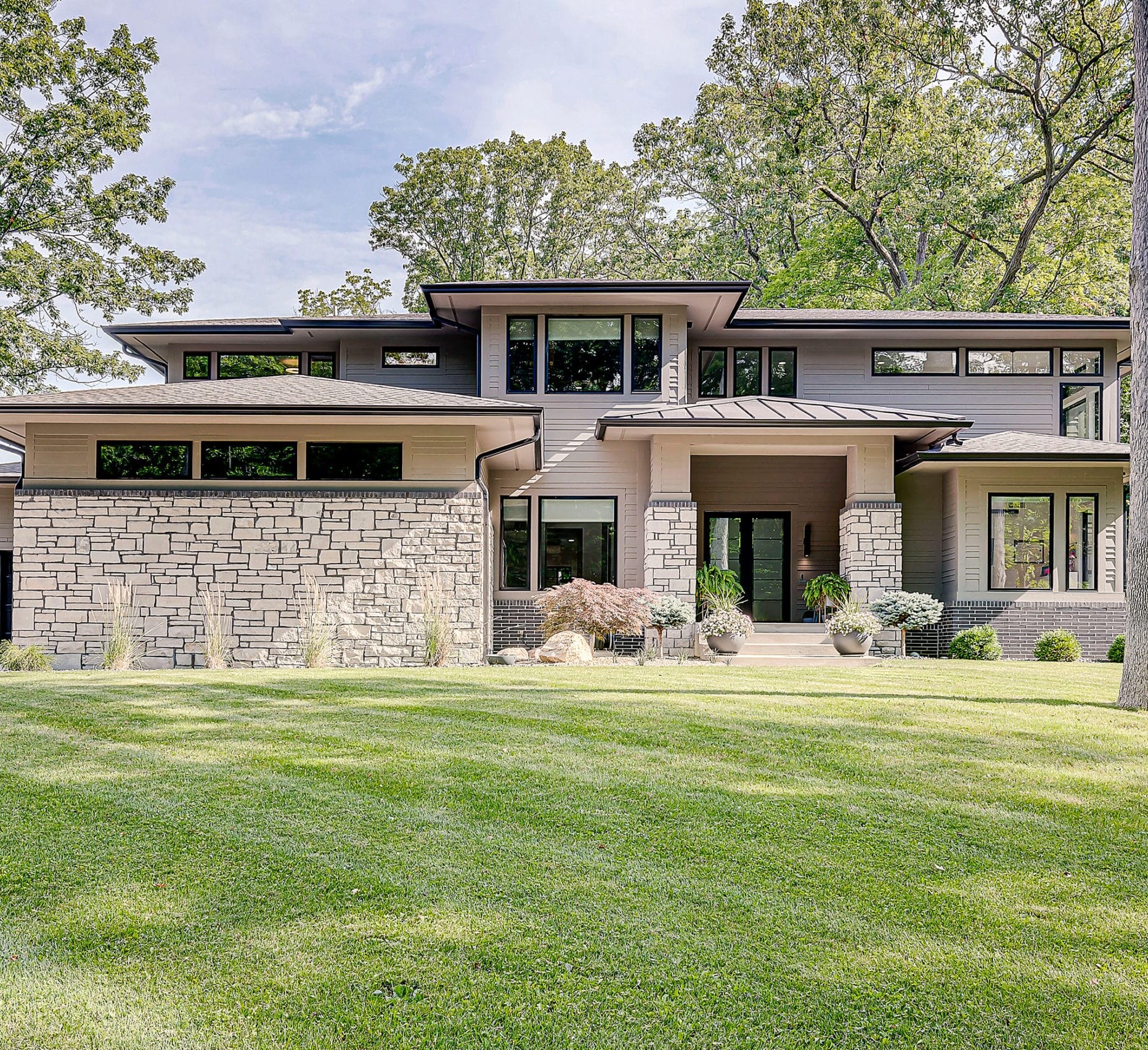 A modern home surrounded by a spacious grassy yard, built by Indianapolis Custom Homes.